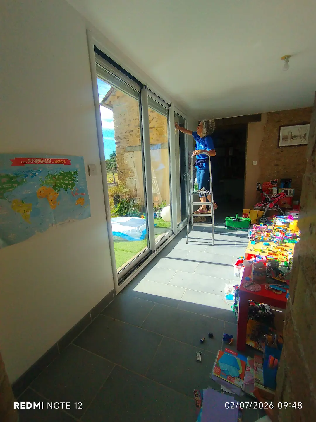 Nettoyage manuel d’une baie vitrée dans une maison à Val-de-la-Hune
