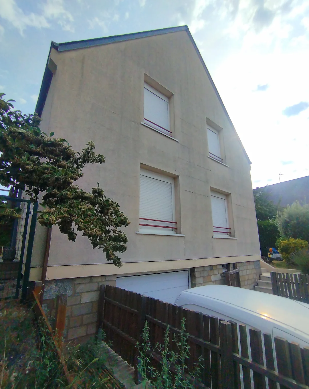 Façade avant avec des traces noires et des fissures visibles sur l’enduit